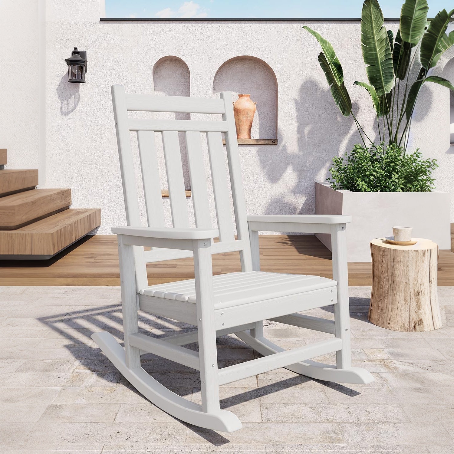 white Adirondack rocking chair displayed in a bright outdoor patio setting