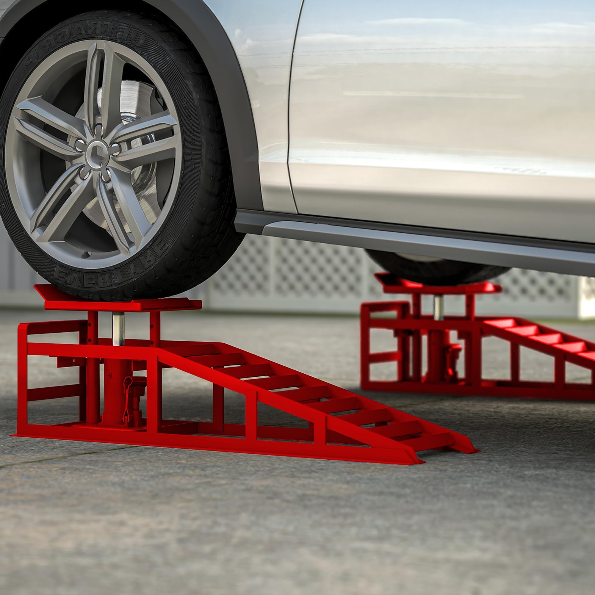 Red hydraulic car ramps lifting a vehicle for garage maintenance