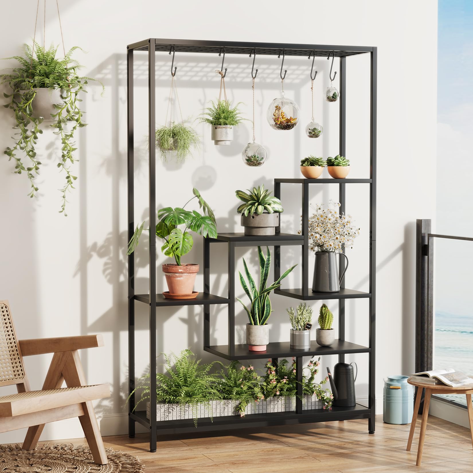 Black 5 tier plant stand displaying potted and hanging plants in a bright room