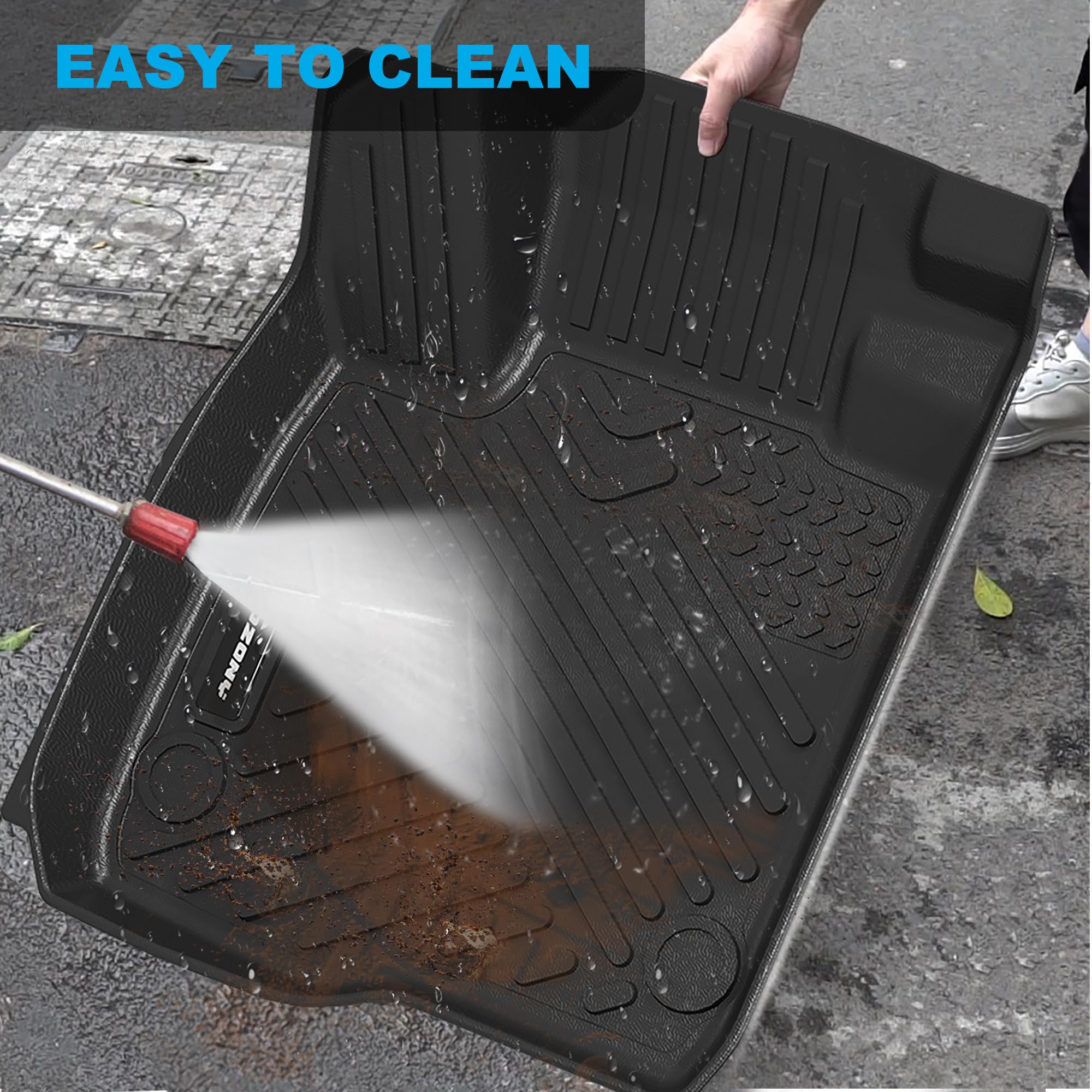 black raised-edge floor liner being rinsed clean with water