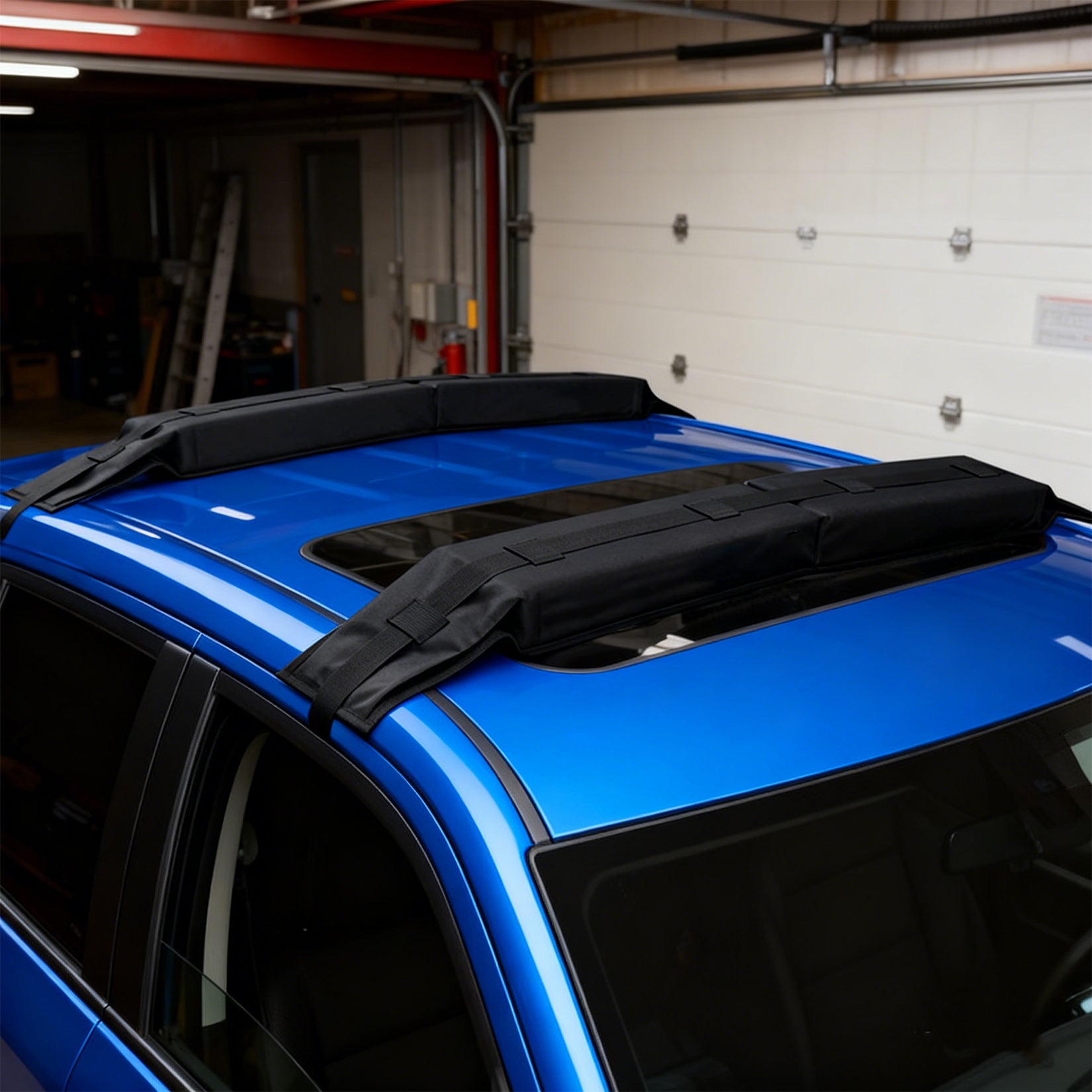 Black soft roof rack pads installed directly on a blue vehicle roof